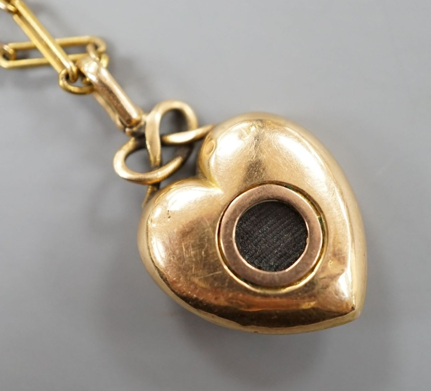 An Edwardian yellow metal and seed pearl set heart shaped locket, with glazed panel back, overall 29mm, on a yellow metal ovoid and spherical link chain, 61cm and a 9c fine link chain (a.f.)